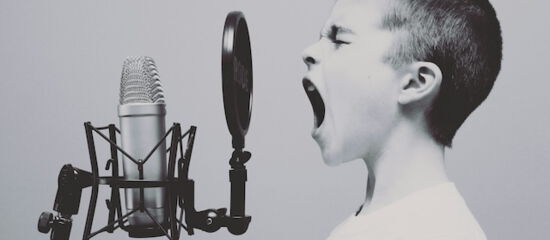 Kind singt in ein Mikrofon